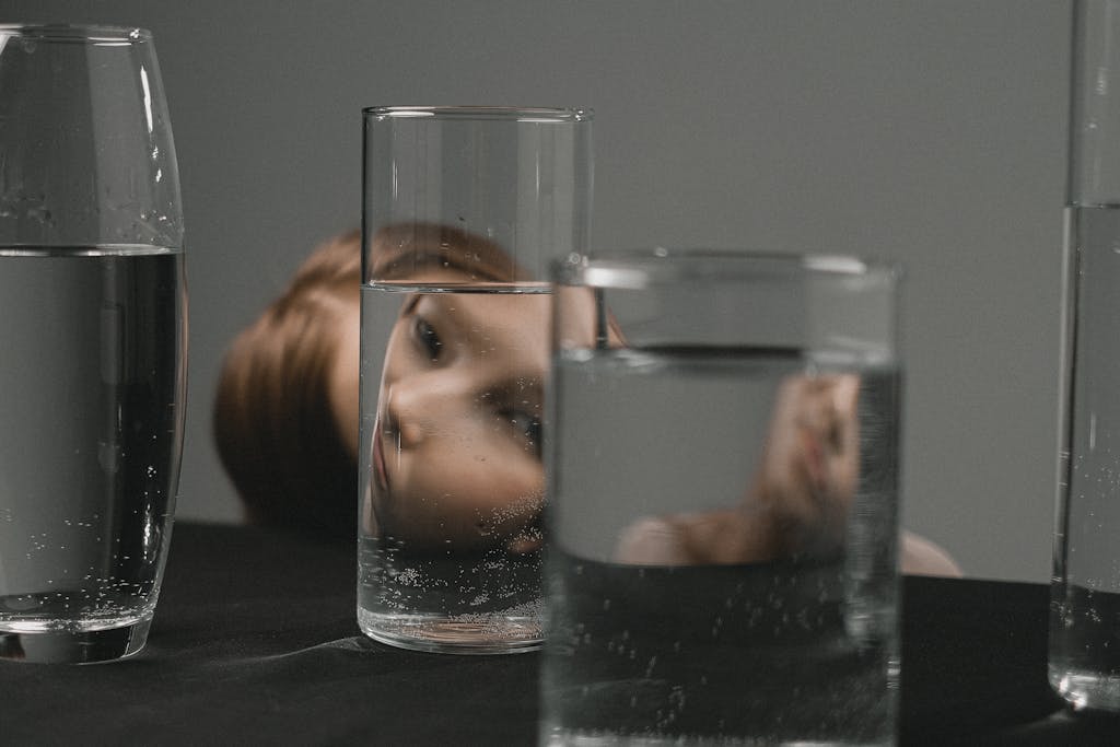 Woman looking through glass with water